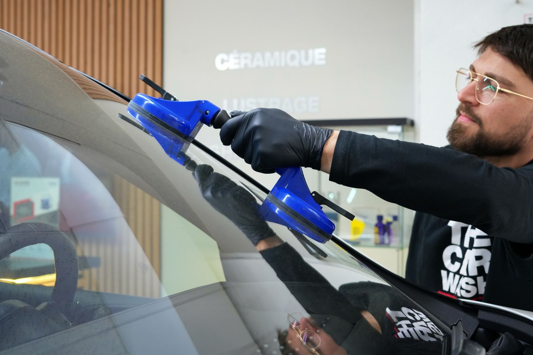 Technicien posant un pare-brise neuf à l'aide de ventouses dans notre atelier