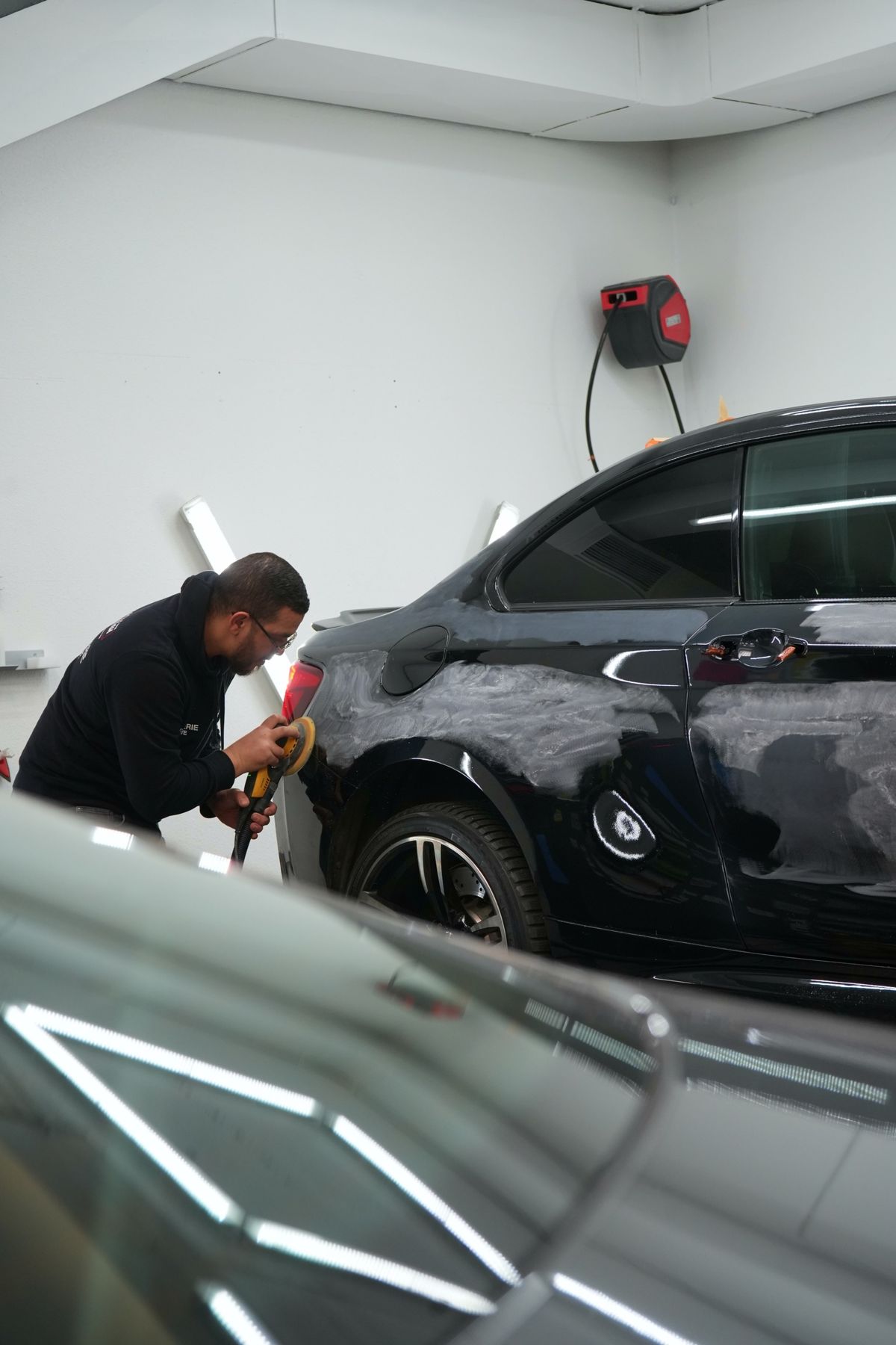 Ponçage de l'aile arrière d'une BMW noire
